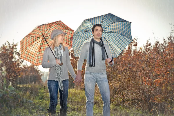 Jeune couple sous parapluie sous la pluie — Photo