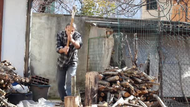 Young man is chopping wood — Stock Video