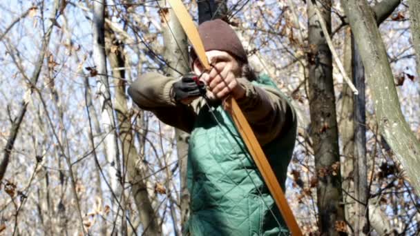 Человек с длинным луком в лесу — стоковое видео