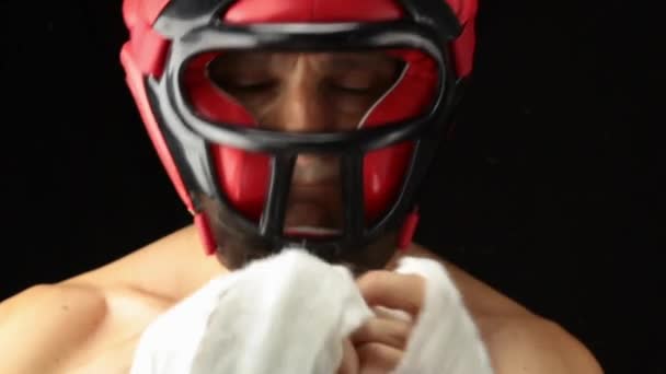 Молодой боксер обвязывает руку бинтами перед боем — стоковое видео