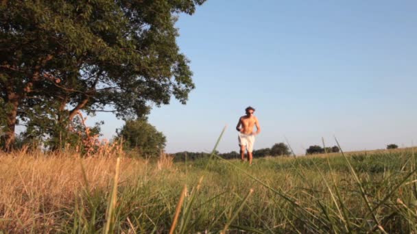 Jeune homme courant dans la forêt — Video