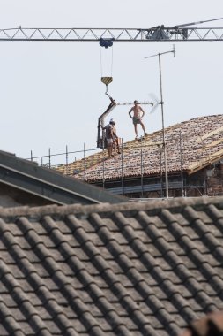 bir çatı üzerinde çalışıyor
