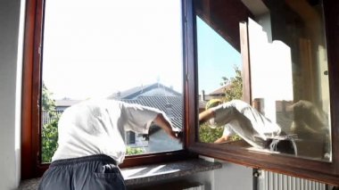 adam eski bir pencere çerçevesi üzerinde zımpara kullanarak