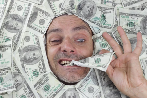 Mann unter einem Bett voller Dollars — Stockfoto