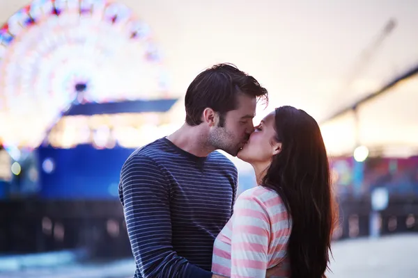 Young couple kissing near santa monica pier — Stock Photo, Image