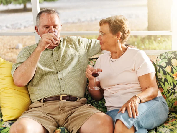Elderly couple drinking on patio — Stock Photo, Image