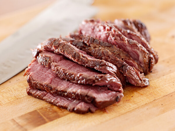Steak sliced thin on a cutting board