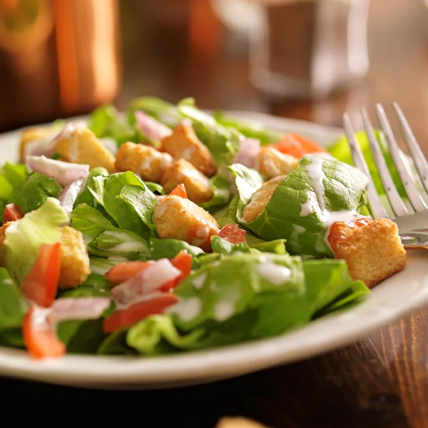 Salat mit Ranch-Dressing, Tomaten, Zwiebeln und Croutons — Stockfoto