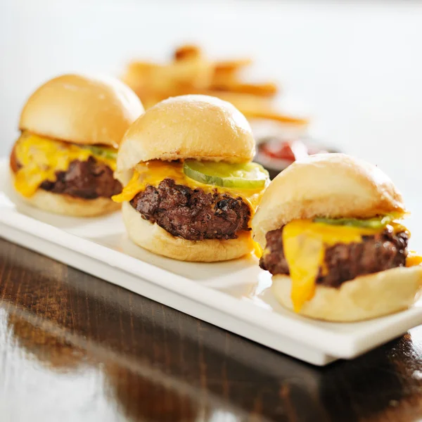 Three burger sliders with cheese and pickle — Stock Photo, Image