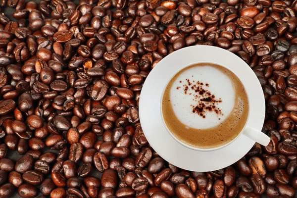 Вид сверху на чашку кофе с кофейными бобами . — стоковое фото