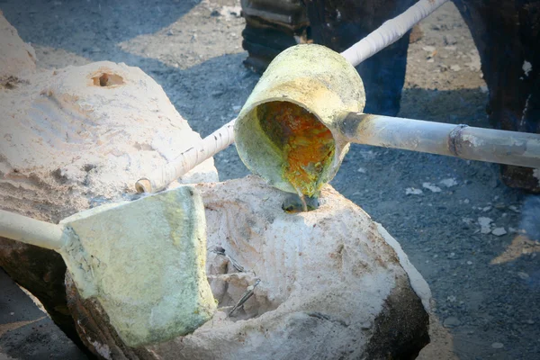 Molten gold being poured from a foundry crucible — Stock Photo, Image