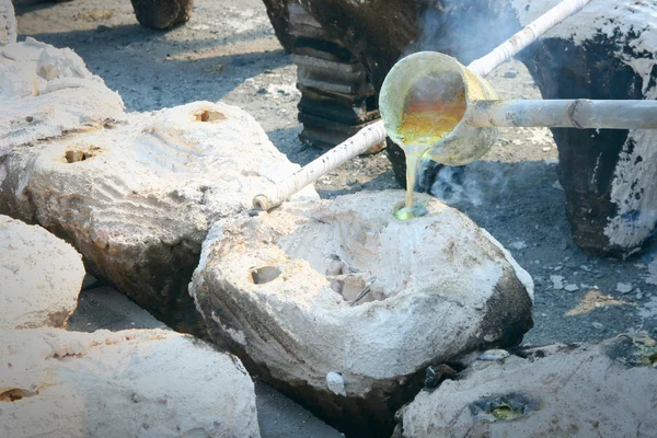 Molten gold being poured from a foundry crucible — Stock Photo, Image