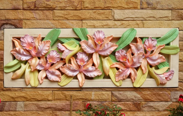 Blumen-Orchideen-Skulptur an einer Wand — Stockfoto