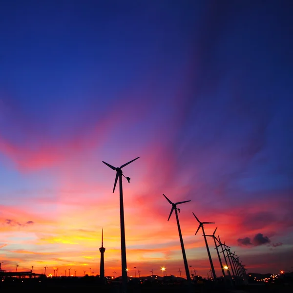 Čisté energie Větrná turbína, siluety fungují v soumraku. — Stock fotografie