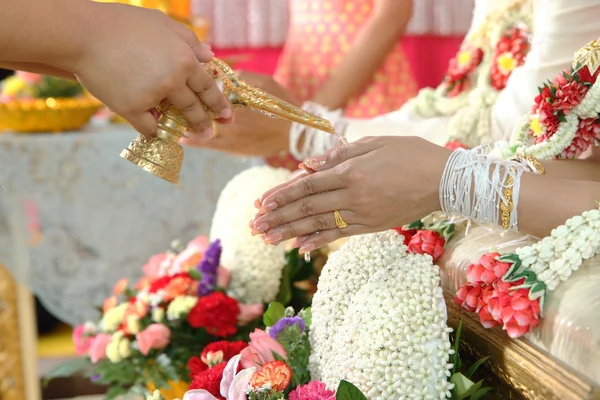 Hands pouring blessing water into bride's bands — Stock Photo, Image