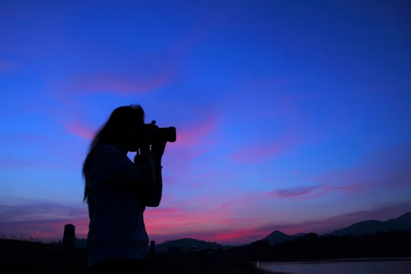 Silhouette of young photographer — Stock Photo, Image