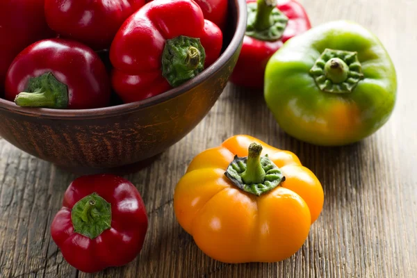 Pimientos rojos, verdes y amarillos frescos de pimentón maduros en un tazón en la mesa de la cocina — Foto de Stock