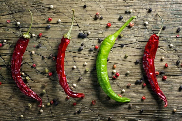 Red and green chili peppers and pepper mix on vintage wooden table background — Stock Photo, Image