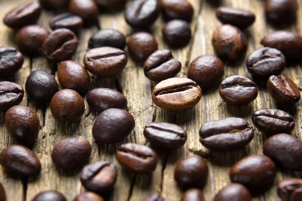 Koffiebonen op vintage houten tafel — Stockfoto