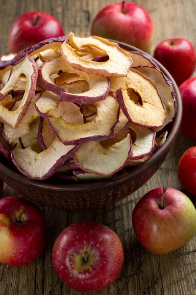 Dried apples in bowl on rustic kitchen table — Stock Photo, Image