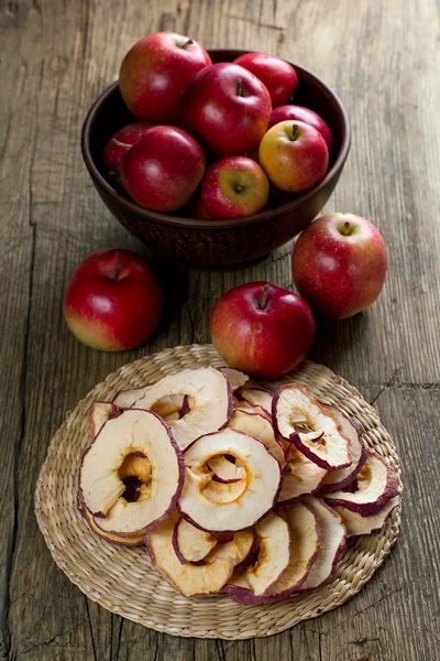 Dried and fresh ripe apples on rustic kitchen table — Stock Photo, Image