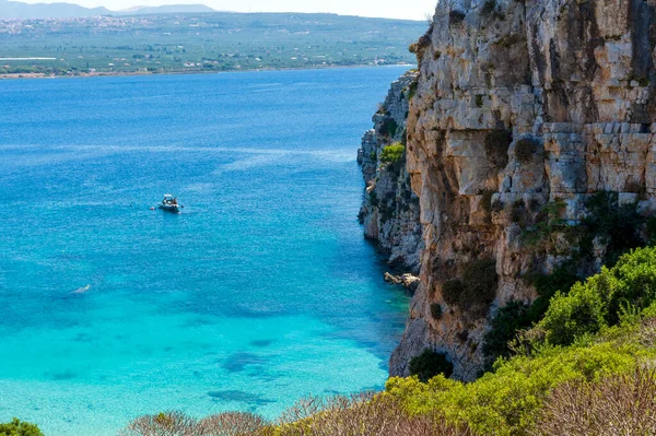 人々は ペロポネソスのメッシニア州マラソポリ近くのプロティ島の澄んだ青い海で泳いでいます 島の名前はポセイドンの息子である古代の海神プロテウスに由来する — ストック写真