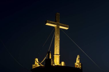 Kythira 'daki Myrtidia Manastırı' nın üzerindeki 7 metre yüksekliğindeki büyük metal haç. Taş zemindeki yazıtlara göre haç, Avustralya 'daki bir Kythera göçmeninin manastırına bir övgü niteliğinde. Buradan Monas 'ı görebilirsin.