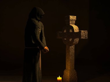 Hristiyan keşişin başı eğik, bir taş haçın önünde meditasyon yapıyor.