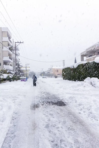 Atina 'da bir kar fırtınası sırasında, Yunanistan' ın başkenti Avrupa 'da, Vrilissia bölgesinde kar yağdı. Sokakta bir adam yürüyor..