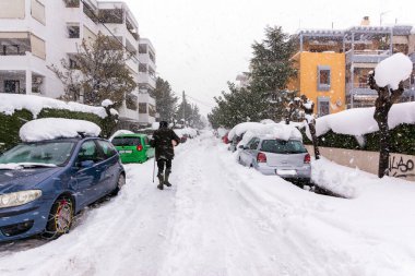 Atina 'da bir kar fırtınası sırasında, Yunanistan' ın başkenti Avrupa 'da, Vrilissia bölgesinde kar yağdı. Sokakta bir adam yürüyor..