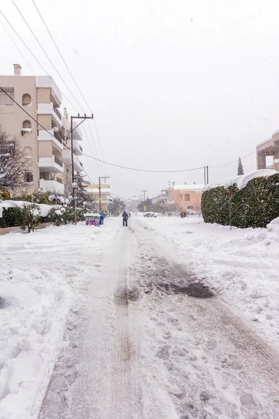 Atina 'da bir kar fırtınası sırasında, Yunanistan' ın başkenti Avrupa 'da, Vrilissia bölgesinde kar yağdı. Sokakta bir adam yürüyor..