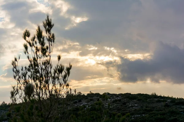 ギリシャアテネのペンテリ地域からの日没の眺め 雲の背景を持つ山の上に落ちる太陽 — ストック写真