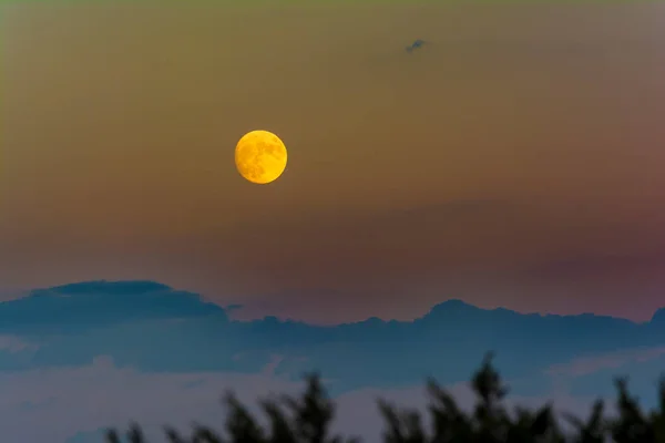 Full golden moon above the clouds. Greece.