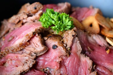 Dilimlenmiş orta pişmiş biftek. 