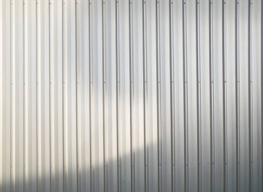 Beyaz kıvrımlı metal levha arka planında gündüz gölgesi