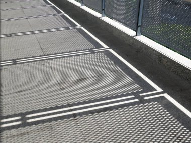 Gün ışığı gölgeli metal tel çitlerin görüntüsü