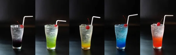 Set of fresh summer cocktail with straws and ice cubes. Glass of cocktail soda drink on dark background.