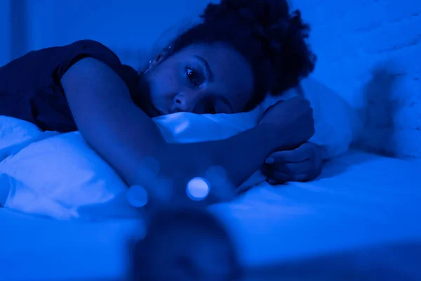 年轻美丽的非洲裔美国妇女深夜躺在床上试图入睡 患有失眠 睡眠障碍或害怕做恶梦 看上去精神压力大 忧心忡忡 — 图库照片