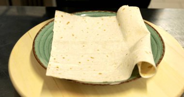 Şef et ızgarasını pide ekmeğine yatırır.