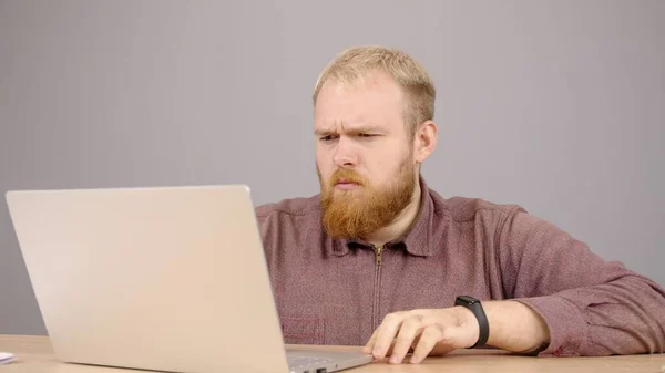 動揺白人男性はフレンドリーな通信を楽しんでノートパソコンのテキストメッセージを使用しています. — ストック写真
