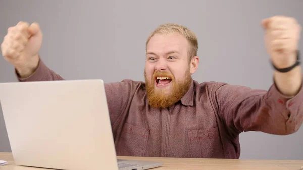 Heureux homme d'affaires caucasien barbu travaillant sur ordinateur portable de bureau à domicile. — Photo