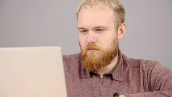 Happy bearded caucasian business man working on laptop from home office. — 图库照片