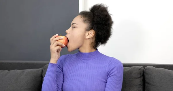 Portrait of a black woman biting a green apple. — Stock Photo, Image