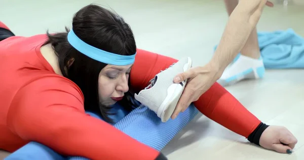 Şişman genç bir kadın yerde spor yapıyor göbek yağları ve kilolarından kurtulmak için.