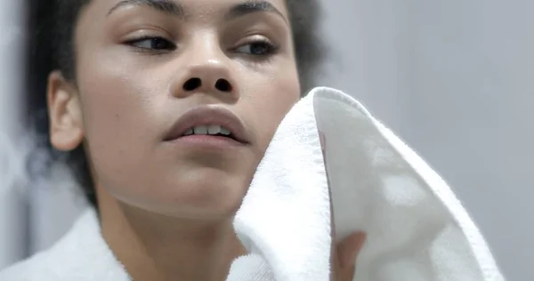 Een aantrekkelijke zwarte vrouw veegt haar gezicht na een douche. Rechtenvrije Stockafbeeldingen