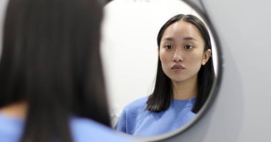 Genç Asyalı kadın virüs bakterilerine karşı yüz maskesi takıyor..