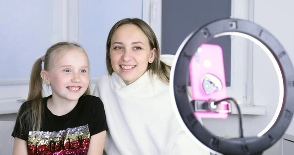 Anne ve kızı akıllı telefon kamerasıyla bir video bloğu kaydediyor..