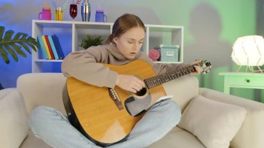 Neşeli kız evde gitar çalıyor.. 