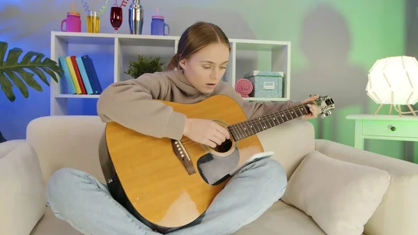 Cheerful girl playing guitar at home. — Stockfoto