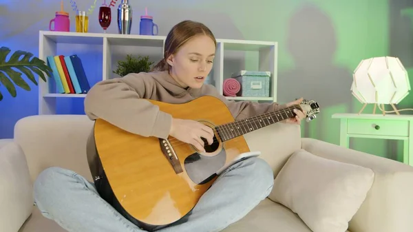 Chica alegre tocando la guitarra en casa. — Foto de Stock